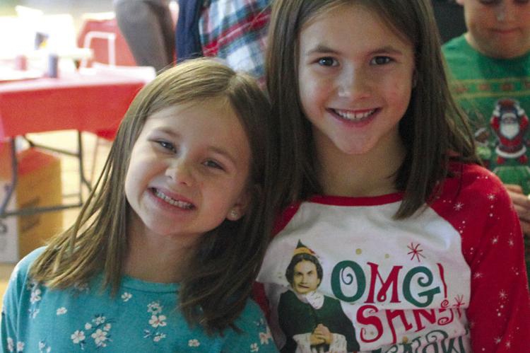 JAYLA (LEFT) AND Jenna Meyer happily wait their turn to paint at a craft booth while visiting the Elf Factory. MIRANDA JAMISON | Staff