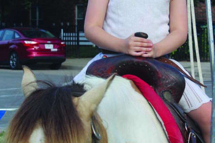 MIRANDA JAMISON | Staff Aurora Covert sits on a pretty pony provided by Patsy’s Pony Rides. Lawson 4-H members Zoey Bush (from left) Georgia Keighley and Caden Kutzli promote 4-H at Waterfest. SHARON DONAT | Staff