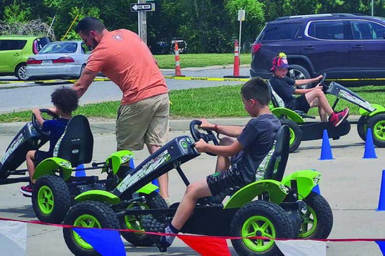 MIRANDA JAMISON | Staff Pedal cars are a hit as these youngsters steer around traffic cones.