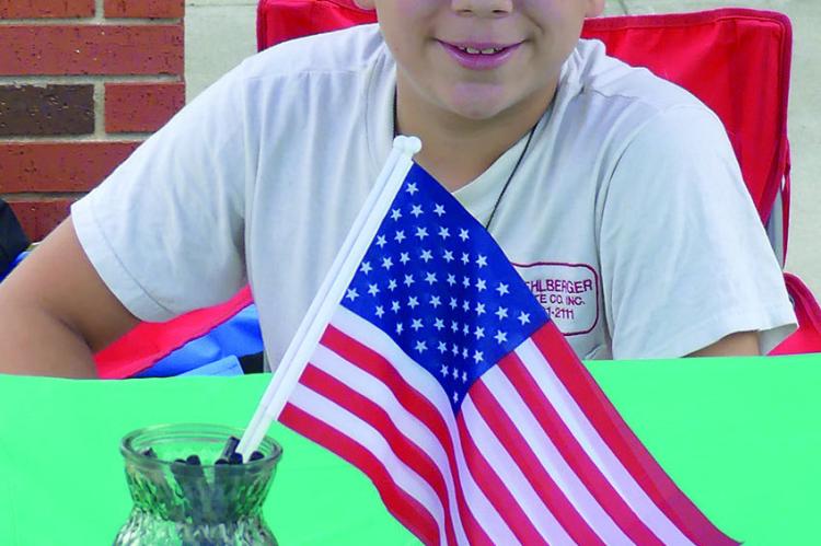 ELIZABETH BARNT | Staff ISAIAH PEREZ set up his tent to promote his lawn care business.