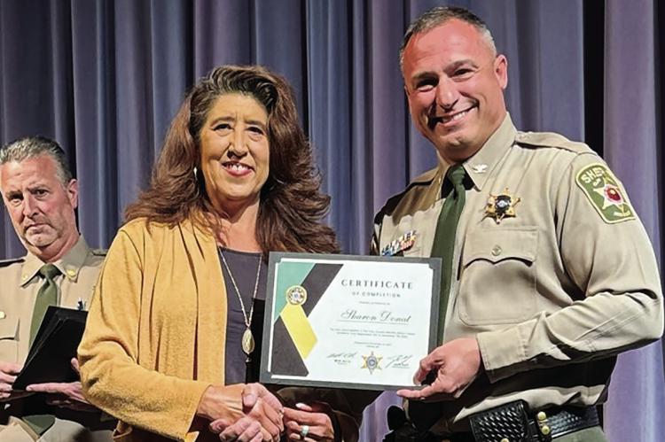 SHARON DONAT (left) receives a certificate from Clay County Sheriff Will Akin. MIRANDA JAMISON | Staff