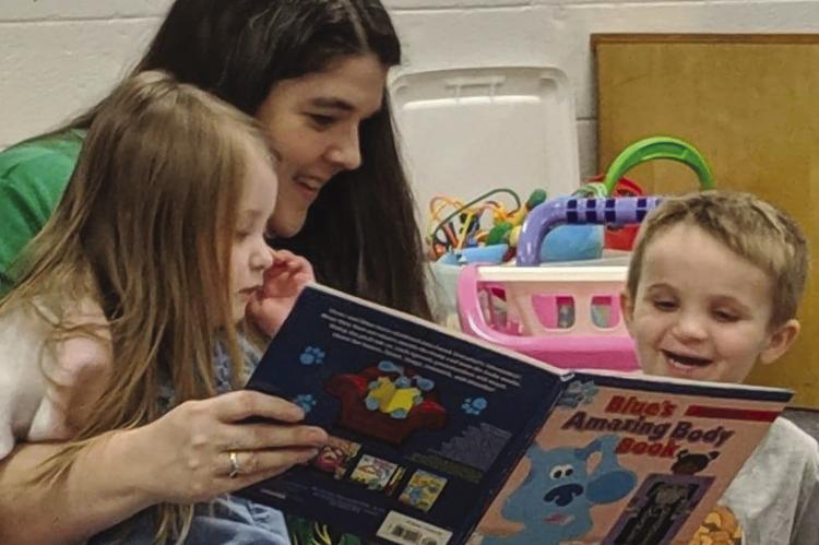 KATHY EMERY (center) reads a story to Vernabelle Souders (left) and Elijah Frost during a Parents as Teachers get together. KATIE FROST | Submitted