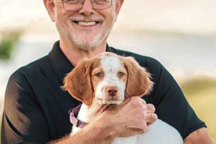 DR. PETE RUCKER holds a young spaniel. DIMPLES AND DAYDREAMS | Submitted