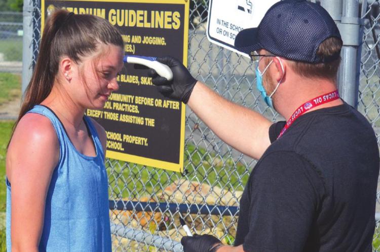 Athletic Trainer Brett Morton checks sophomore Sydney Jarvis' temperature before she participated in summer conditioning Tuesday. DUSTIN DANNER | Staff