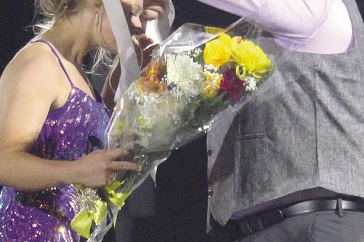 CLAY CARLYLE (right) helps Chloe Carlyle (left) accept her title: “Excelsior Springs High School Senior Homecoming Queen” during halftime. MIRANDA JAMISON | Staff