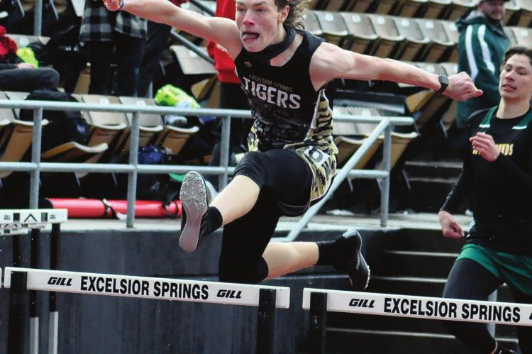 GAVIN WILMES is a high-flying Tiger as he goes airborne during the boys 300-meter intermediate hurdles April 23 in the Mineral Water Classic on a cool, rainy day for high school track and field at Excelsior Springs High School. SHAWN RONEY | Staff