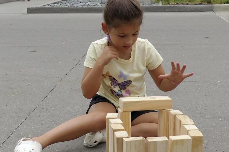 Ava Sheahan plays with building blocks on a warm summer day for Parks and Recreation Month.