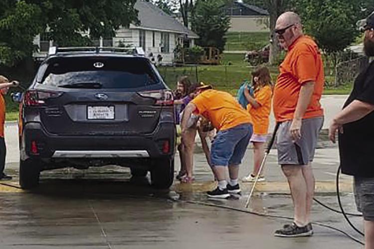 Brayden Wilson (from left), Tyson Taylor, Breanne Poling, Sophi Lee, Jake Souders and Cory Poling wash and rinse cars for a good cause. The proceeds from the car wash, held in honor of late church member Brian Satterfield, are donated to the American Foundation for Suicide Prevention. The group is planning another car wash from 11 a.m. to 5 p.m. on August 12.
