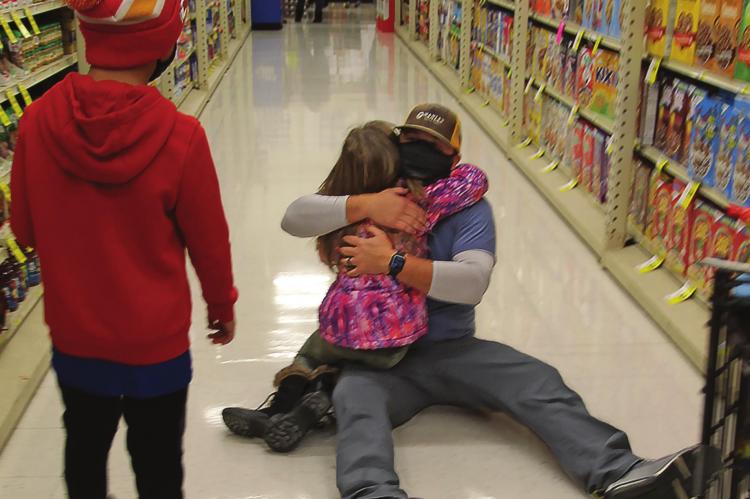 WITH THE SPREE over, an exhausted Kenny Manley drops to the floor, where daughter, Taryn, 8, rushes to his arms.