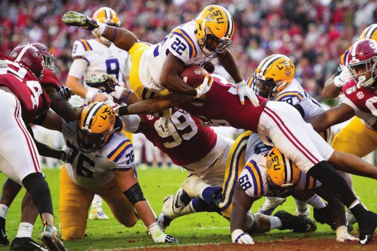 IT TAKES FOREVER for the Kansas City Chiefs to draft Clyde Edwards-Helaire, seen leaping through the University of Alabama defense for LSU. COURTESY OF THE LSU ATHLETICS WEBSITE