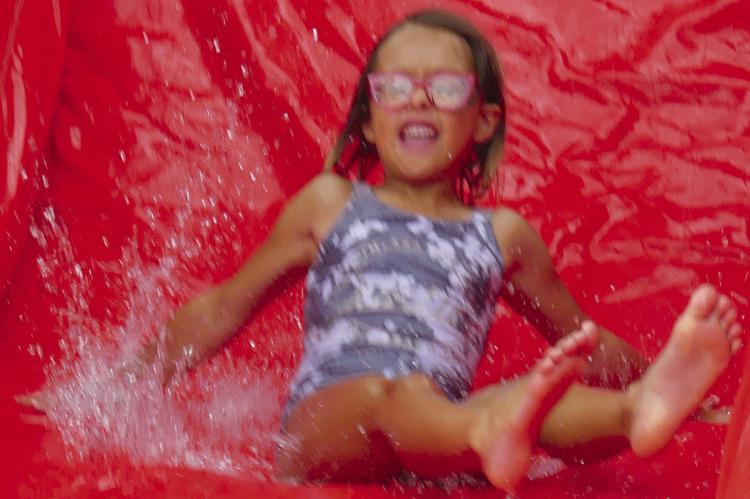 Adeline Daniel makes a splash on the water slide during the Parks and Recreation Month kickoff event. More photos on page 7. ELIZABETH BARNT | Staff