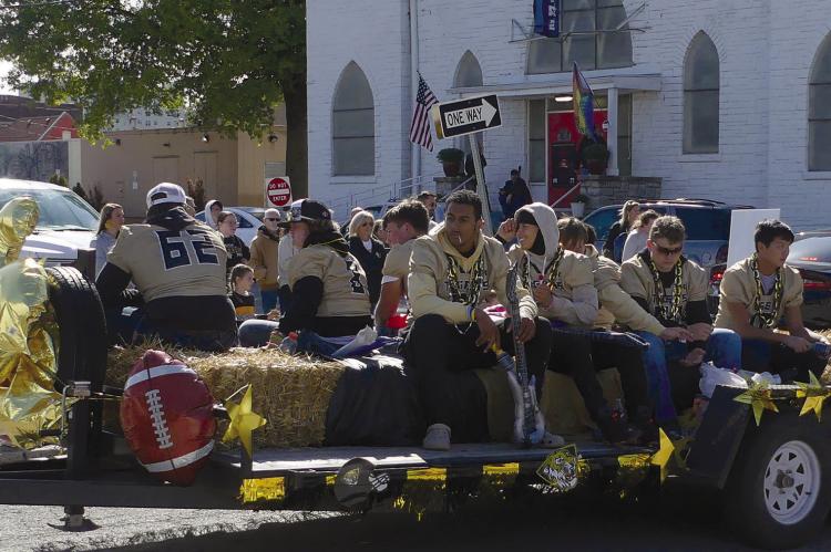 ELIZABETH BARNT | Staff HIGH SCHOOL football players ride on a trailer through the parade.