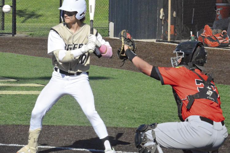 RYNE MARCUM take a pitch high Monday against visiting Oak Grove. The Excelsior Springs sophomore’s contributions to the Tigers’ home victory include two runs scored.