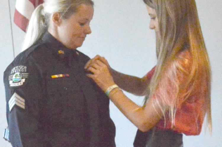 OAKLEIGH NASH pins the sergeant’s badge to her mother, Samantha Nash-St. John, during the July 27 promotion ceremony at the ES Community Center.