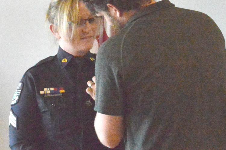 CASSIE CRAMER receives her badge from her husband Josh. Cramer and Samantha Nash-St. John are the first female sergeants in ESPD history.