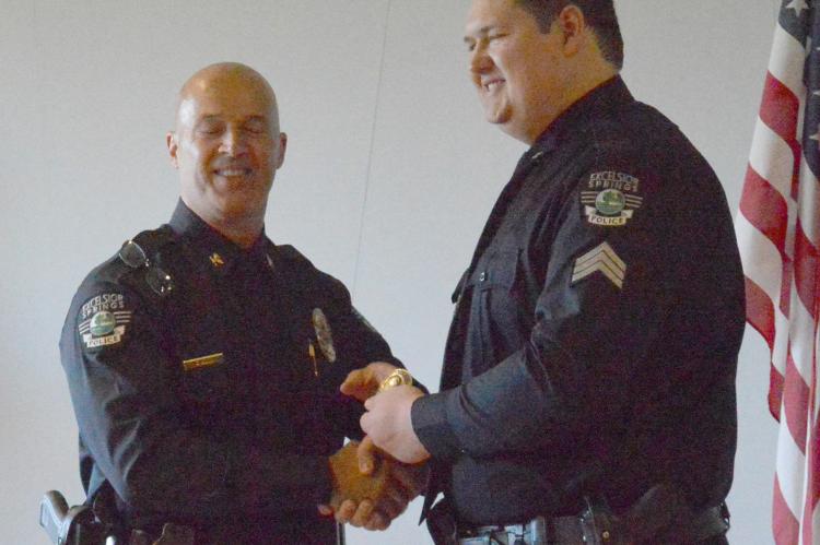 CHIEF GREG DULL and Scott Sickles shake hands after Sickles is promoted to sergeant July 27.