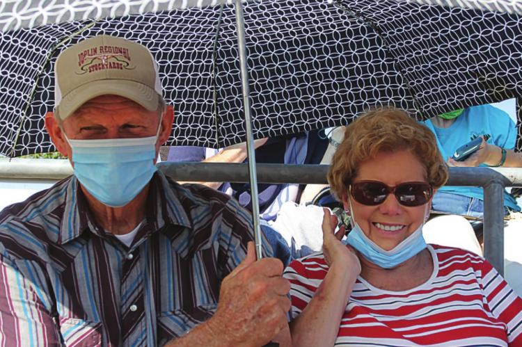 TO KEEP the sun off, David and Linda Bender use an umbrella while waiting for their grandson, Kyle Bender, to graduate. J.C. VENTIMIGLIA | Staff