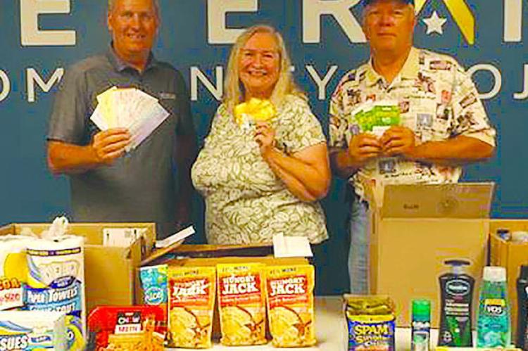 CHRIS ADMIRE (from left) accepted donations from OCC members Barbara and Mike Britt. Submitted