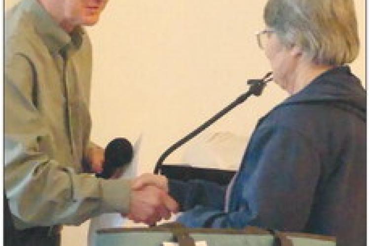 KATHY TWITCHELL shakes Councilmen, Reggie St. Johns hand while she receives her certificate.