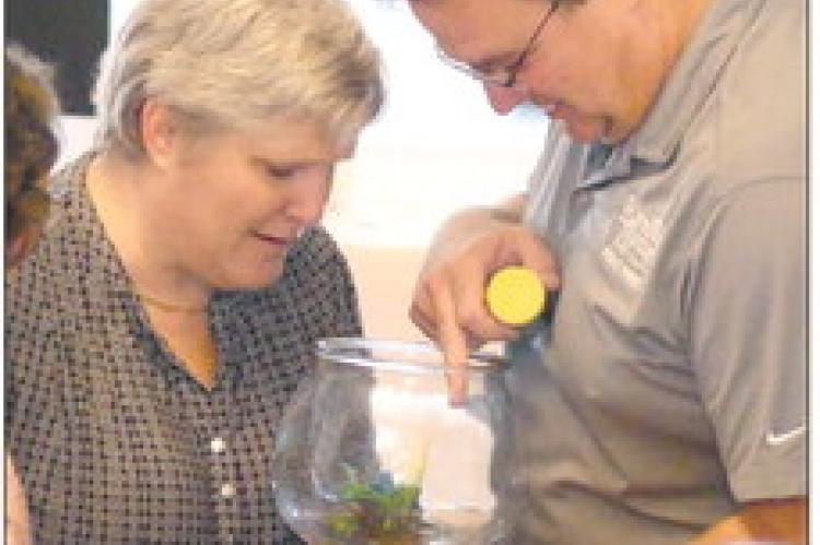 MELINDA MEHAFFY (left) and Chad Birdsong discover two baby turtles in a fishbowl he won during the raffle.