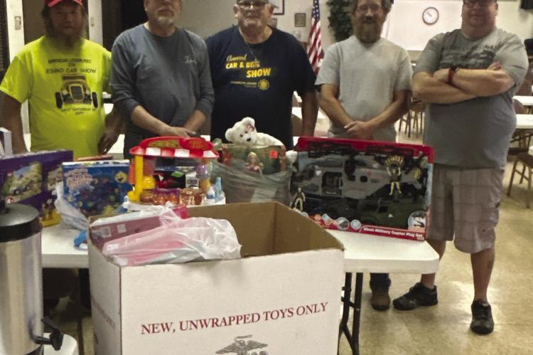 RUSTY HARRINGTON (from left), Rodney Holt, Larry Kerr, Chris Stull and Brock Stout stand behind table of toys collected for children in need. CHRIS STULL | Submitted