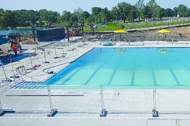 THE OUTDOOR POOL is filled with water and sanitation chemicals are added for public use once the project is complete.