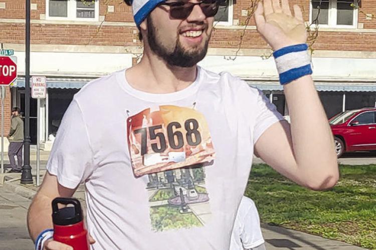 ROBBIE FARABEE PREPARES for a high five after completing the 5K run.