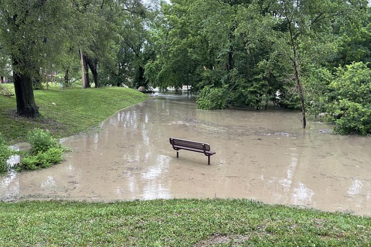 The walking trail behind the Hall of Waters was nonexistent as Fishing River filled several downtown parking lots and Piburn Ball Field with flash flooding Friday morning. Photo by Brian Rice.
