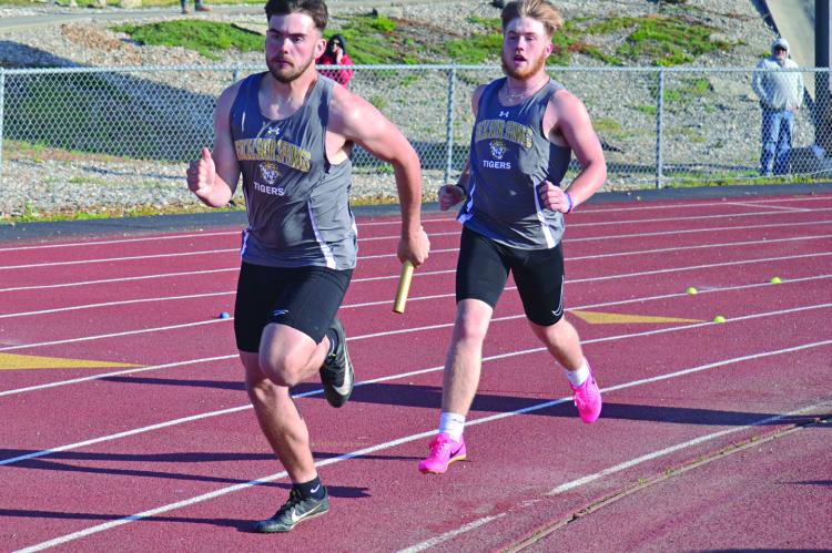 EXCELSIOR SPRINGS sophomore Carson Jackson watches senior Chance Moreland take off after the baton exchange during the boys 400-meter relay April 21 at the Mineral Water Classic at Tiger Classic. DUSTIN DANNER | Staff