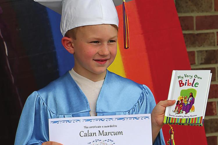 STUDENT Calan Marcum holds his graduation certificate and personal Bible from Noah’s Ark Preschool at Barbee Presbyterian Church.
