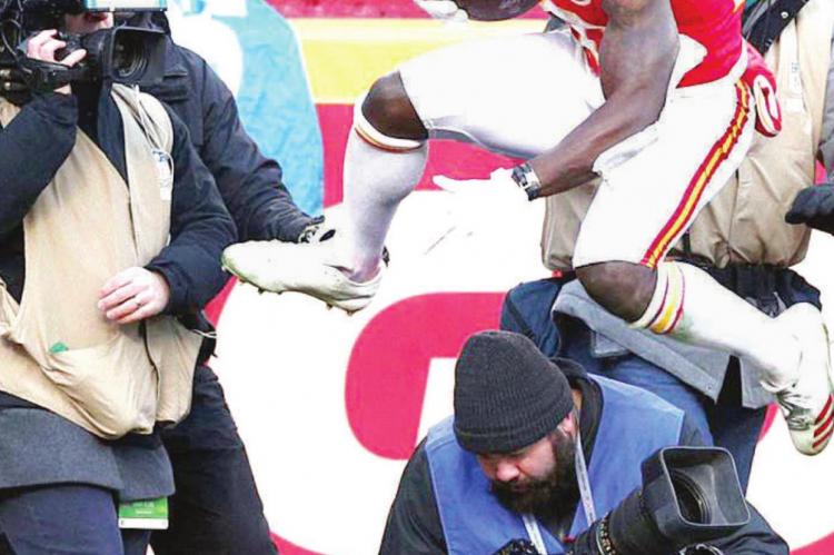 KANSAS CITY receiver Tyreek Hill leaps over a camera operator after being forced out of the end zone during postseason play.