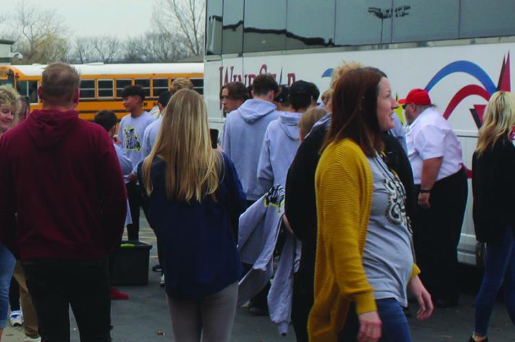 STAFF AND STUDENTS of Excelsior Springs High School, along with community members bid farewell to the soccer team as they board the bus, to be escorted by the Excelsior Springs Police Department.
