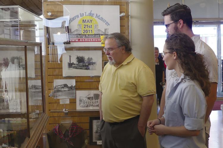 Jack Miles (from left), Sam Zimmerman and Rachel Grace admire Robert Grace’s artwork on display during the open house. ELIZABETH BARNT | Staff