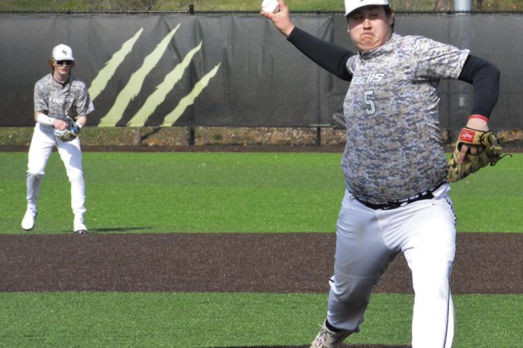 BACKED BY his position players, right-hander Brayden Lewis delivers for Excelsior Springs March 16 against Summit Christian Academy. Lewis, a senior, is expected to lead the Tigers’ youthful pitching staff this season.