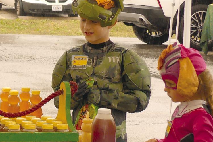 ZANDER (LEFT) AND Kinsley Spohn collect candy during the market’s fall festivities.