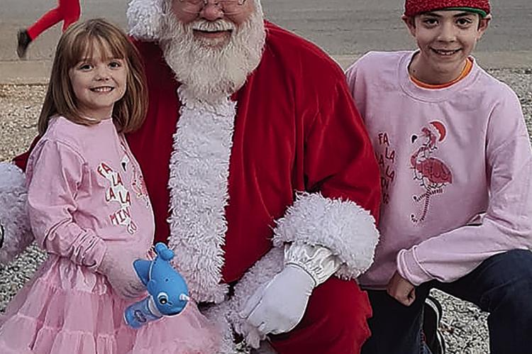 AURORA TAFF (LEFT) AND Charlie Shull flash their beautiful smiles while taking a picture with Santa Claus.