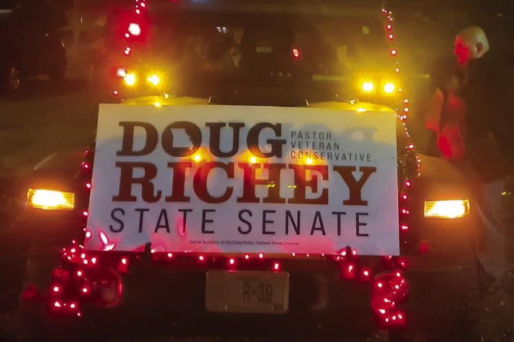 STATE SEN. Doug Richey rides in a Jeep Gladiator covered in Christmas lights for the parade.