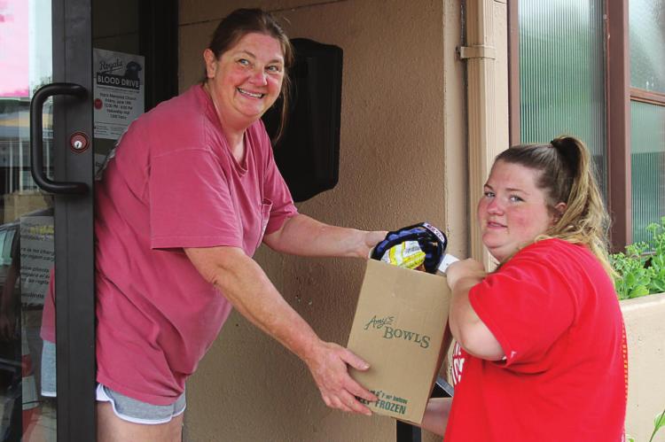 AT GOOD Samaritan Center’s mission, Jennifer and Hope Chappel carry food to aid a family. J.C. VENTIMIGLIA | Staff