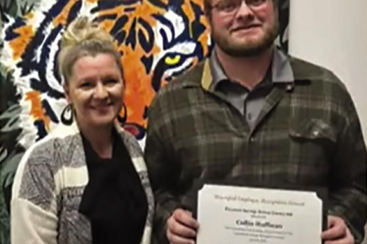 MELISSA MILLER, assistant superintendent (left) awards Collin Huffman, IT technician, an Employee of the Month award for his dedication to the school district. Submitted