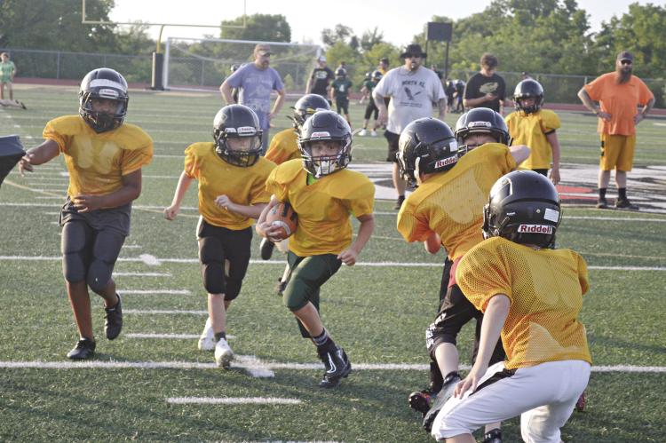 PARKER WAINSCOTT of the Excelsior Springs Football Association’s fifth-grade team runs through the defense during a practice at Tiger Stadium. DUSTIN DANNER | Staff