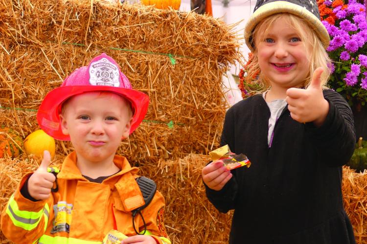 BUBBA (LEFT) AND Evelyn Harrell give a thumbs up in approval of the fall festival farmers market event as they munch on gummy bears. ELIZABETH BARNT | Staff