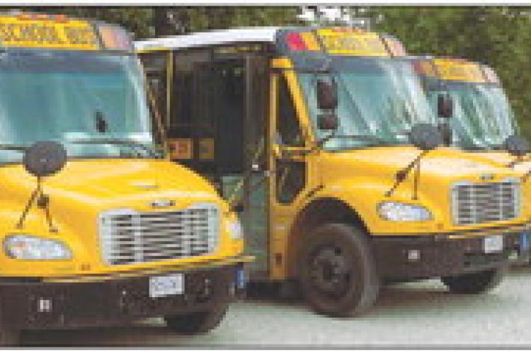 SCHOOL BUSES park in the gravel lot before drivers conduct their pre-trip inspections. ELIZABETH BARNT | Staff