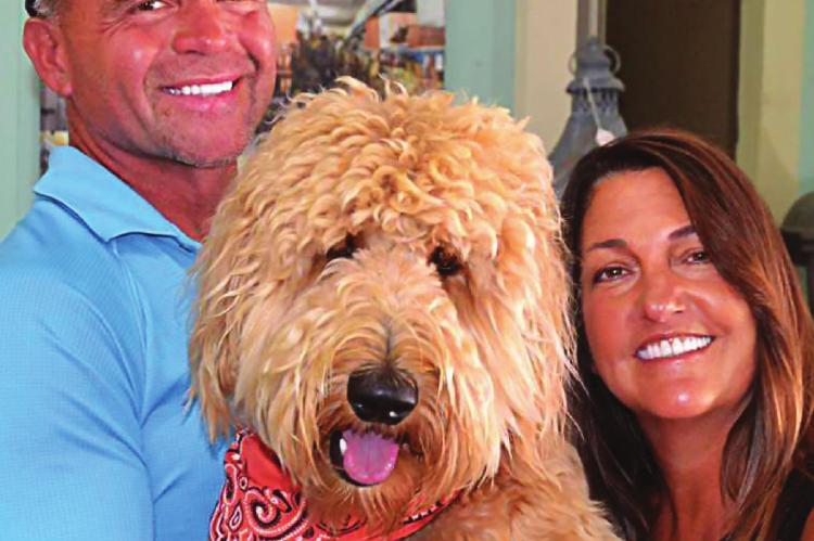 AT BRUNKE, owners Gary and Kim Sanson show off their golden doodle, also name Brunke, which they adopted while renovating their building.