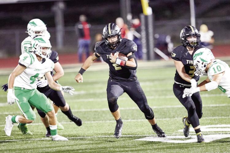 ON A night when yards prove difficult to come by, Excelsior Springs senior quarterback Chance Moreland finds a hole in the line and seeks more running room during the Tigers’ 42-8 Sept. 23 home loss to Smithville. DUSTIN DANNER | Staff